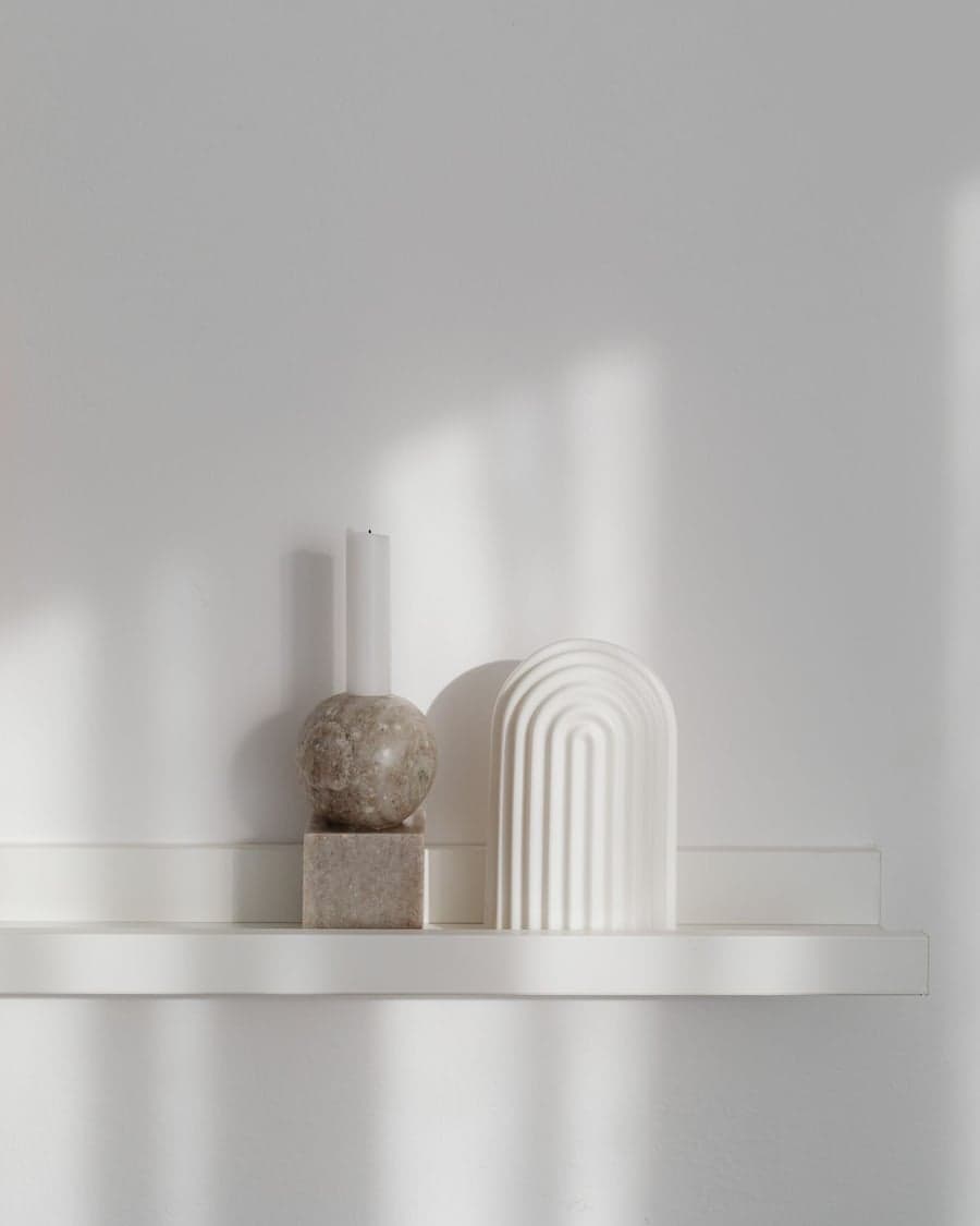 Minimalistische Deko-Objekte auf einem hellen Regalbrett